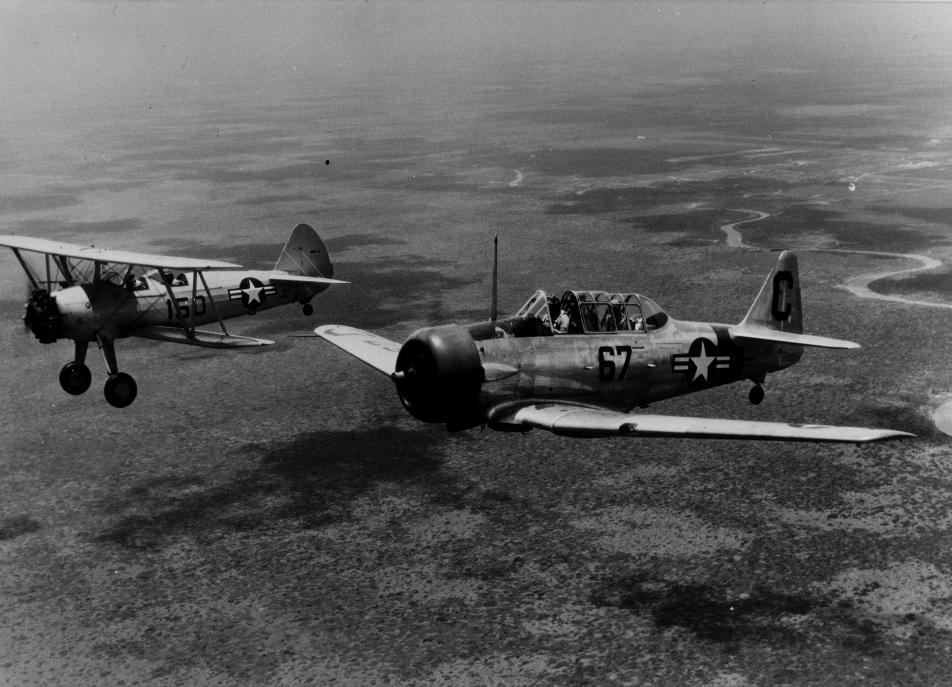 A Navy biplane trainer flies next to a more advanced training aircraft, an SNJ Texan, in the skies near Foley during World War II. The city of Foley is acquiring an N3N biplane trainer of the same models as aircraft used in the area during World War II as part of a planned museum exhibit. 