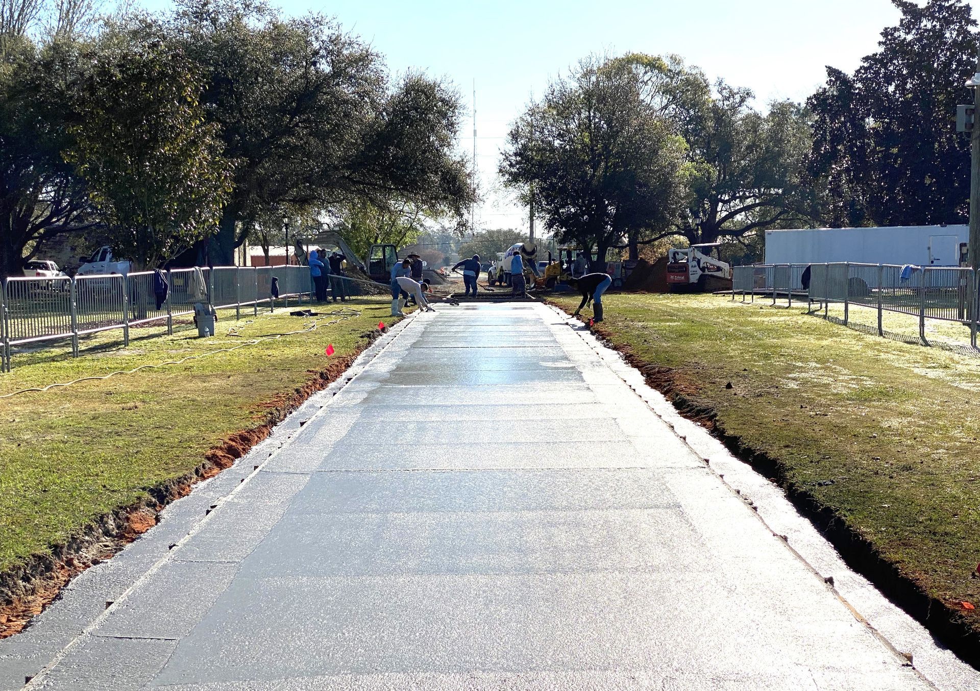 Workers pour concrete to construct the walkway across Heritage Park in Foley.