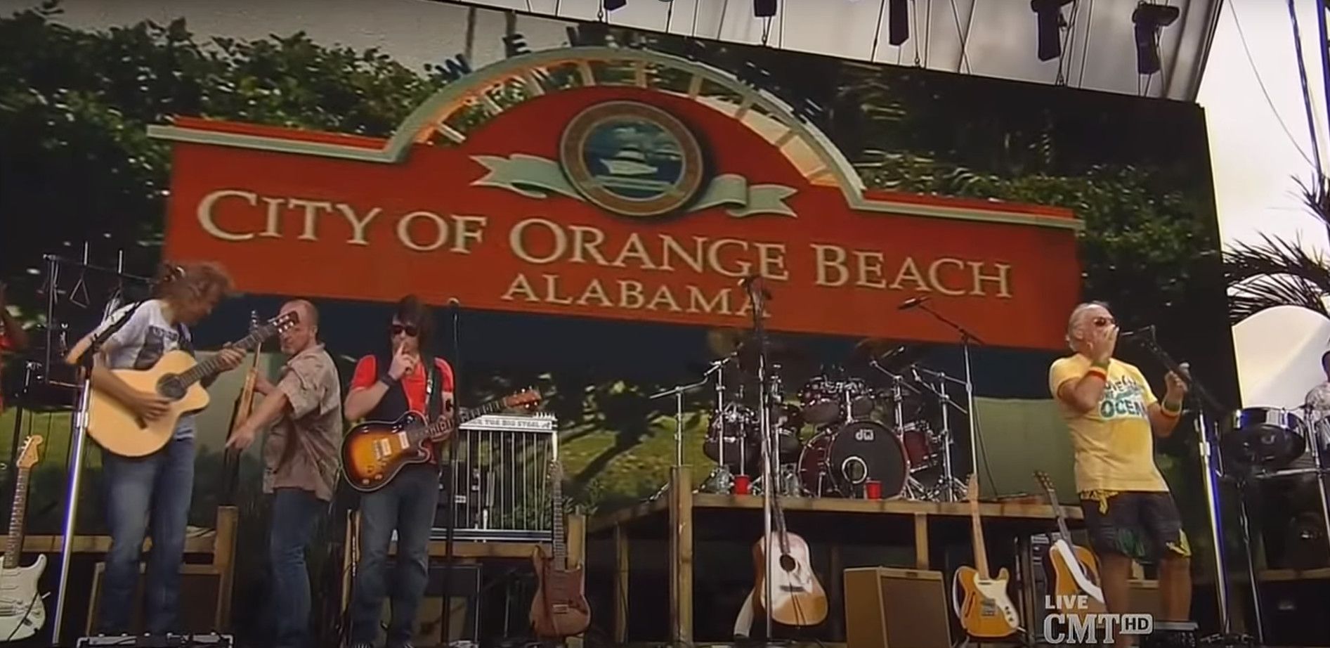Jimmy Buffett on stage in Gulf Shores in front of the City of Orange Beach sign
