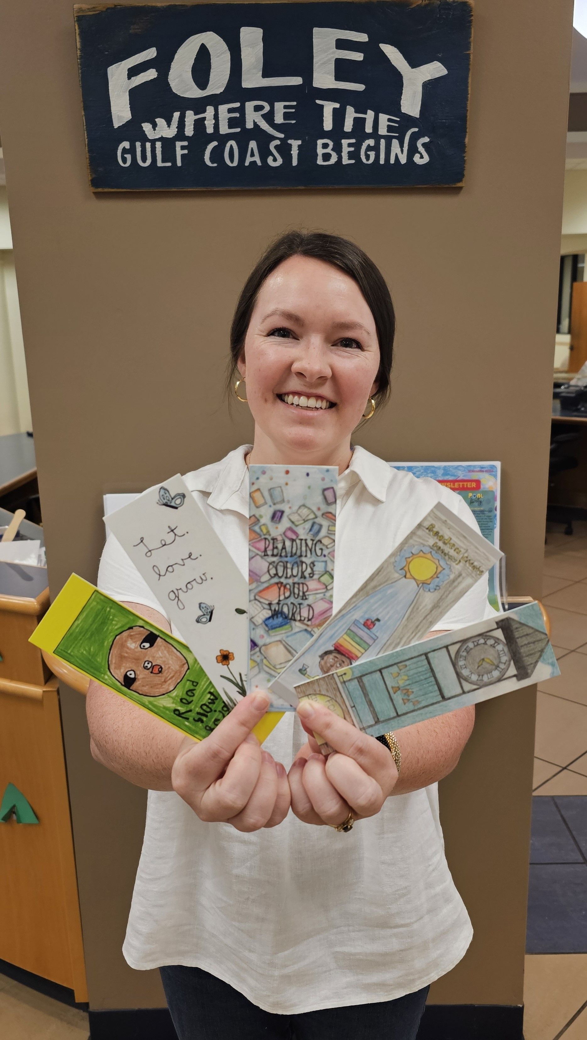 Maggie Pearson, Foley children’s librarian, holds copies of bookmarks selected from the winning designs submitted by local young people. Copies of the bookmarks are available at the Foley Public Library.