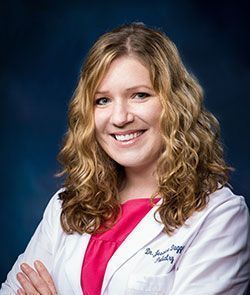 Photo of Dr. Jessica Duggan, DPM wearing a white coat over a pink blouse