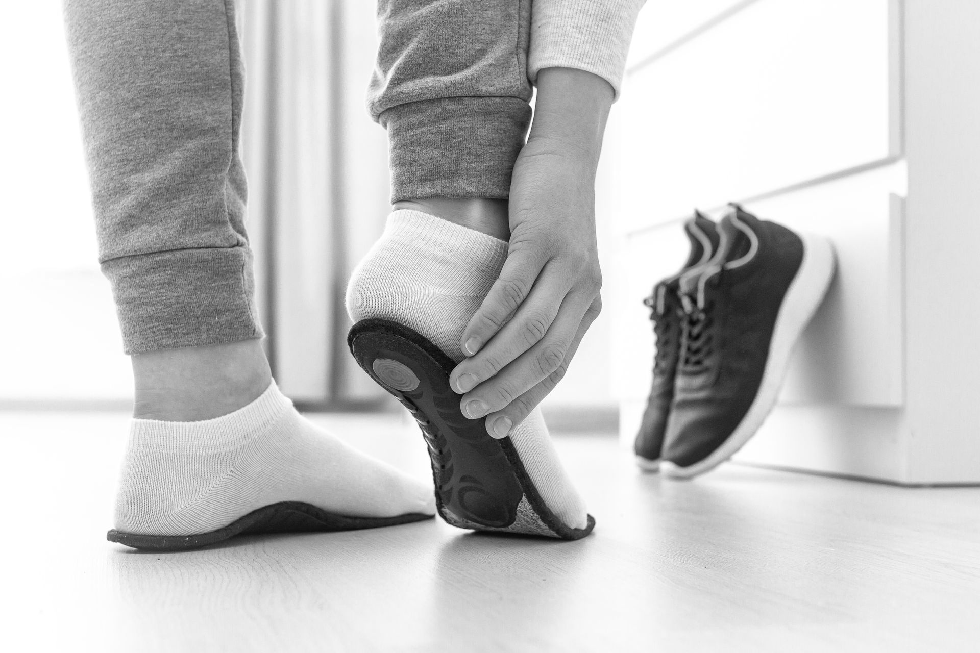Black and white photo of a person's feet trying on orthotic foot wear