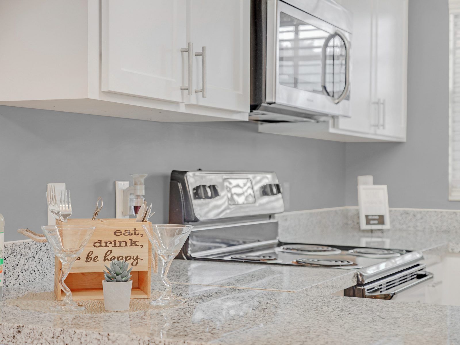 A kitchen with a stove , microwave , and cabinets at Veridian of Melbourne Townhome Apartments in Melbourne, FL.