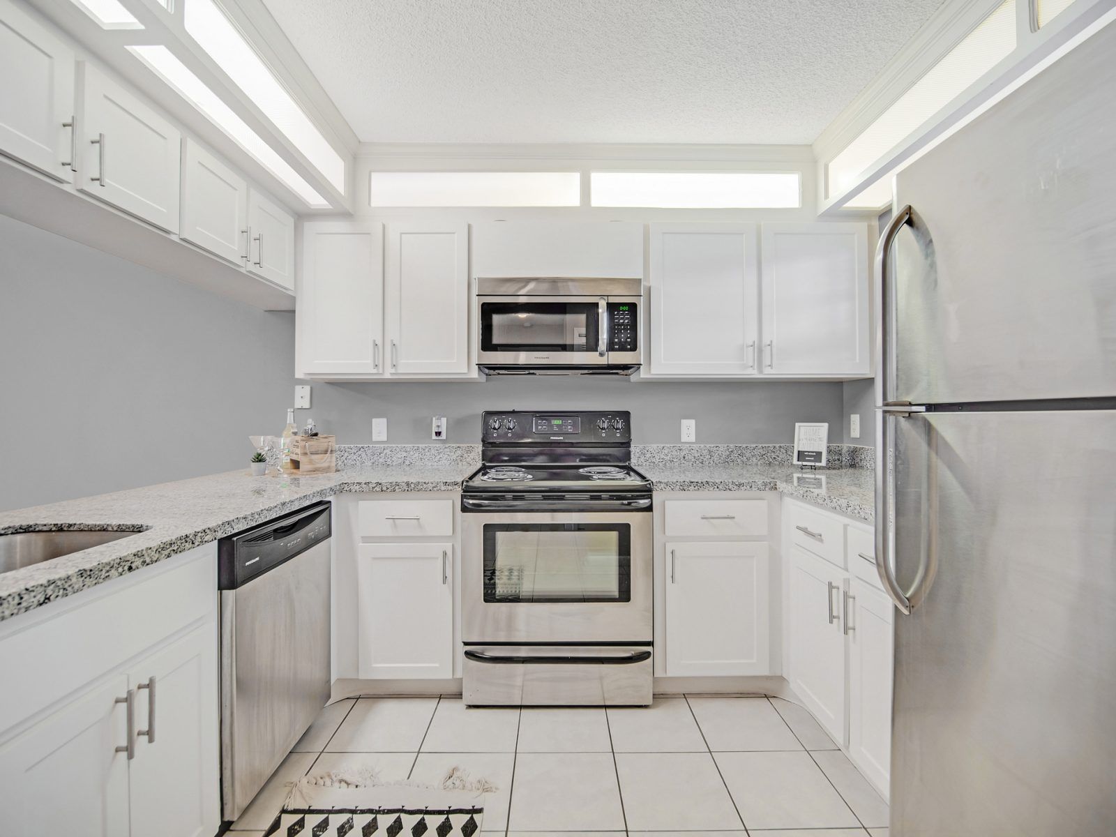 A kitchen with stainless steel appliances and white cabinets at Veridian of Melbourne Townhome Apartments in Melbourne, FL.