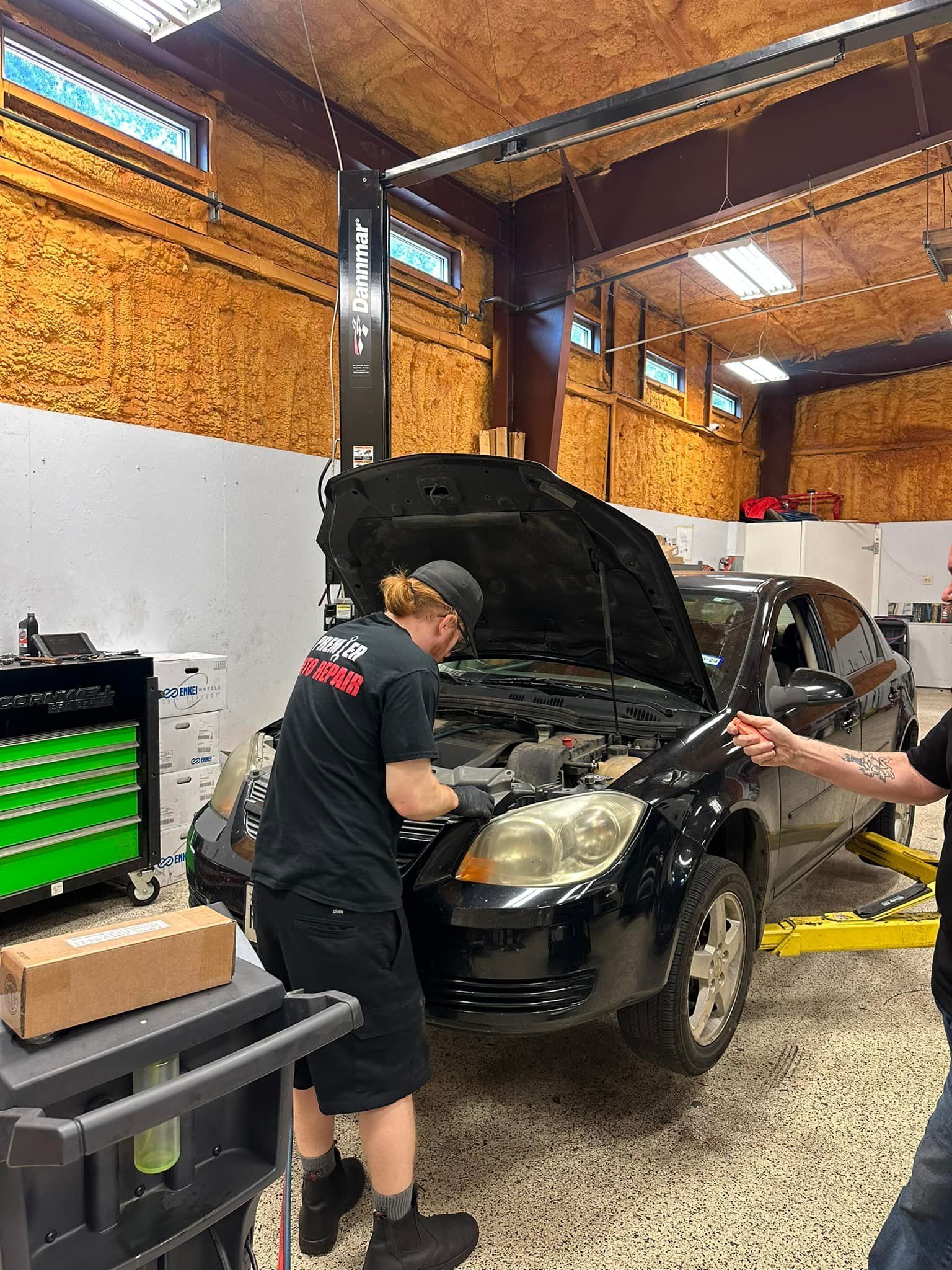 Mechanic Working on a Black Car | Premier Auto Repair