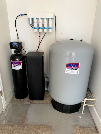 A water filter is sitting next to a large tank in a room.