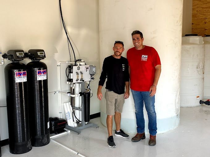 Two men are standing next to each other in a room.