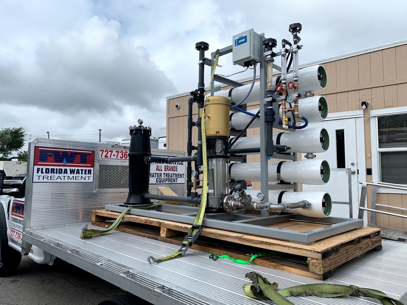 A machine is sitting on top of a wooden pallet on a trailer.