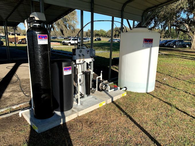 A water treatment system is sitting under a canopy in a park.