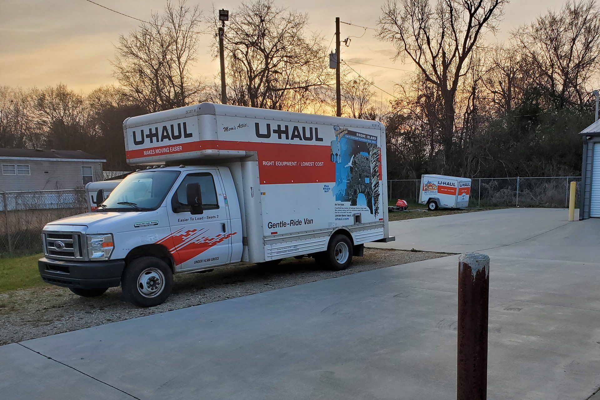 A white and red u-haul truck is parked in a parking lot.
