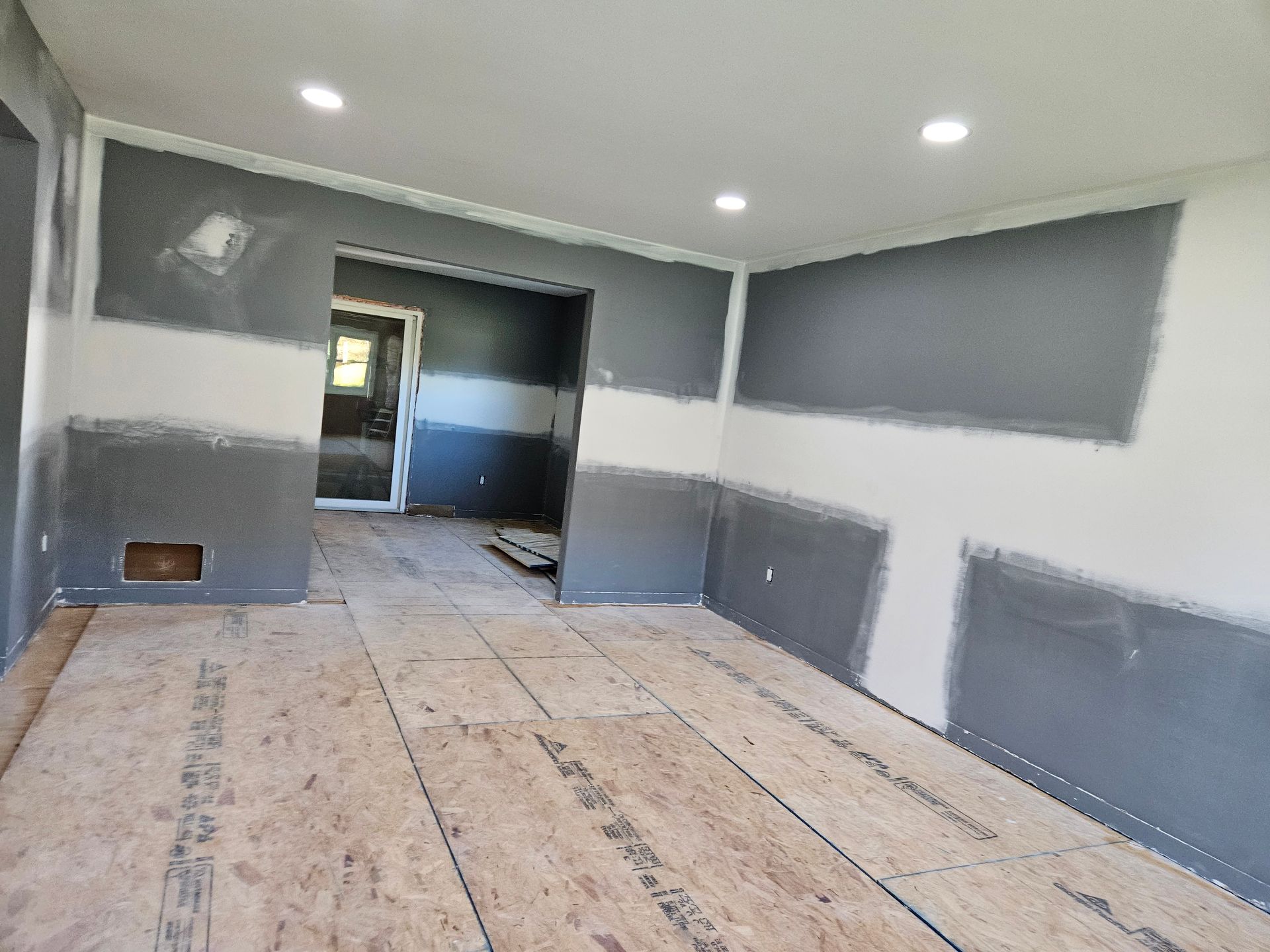 Living room with wicker sofas, white cushions, brown coffee table, large windows.