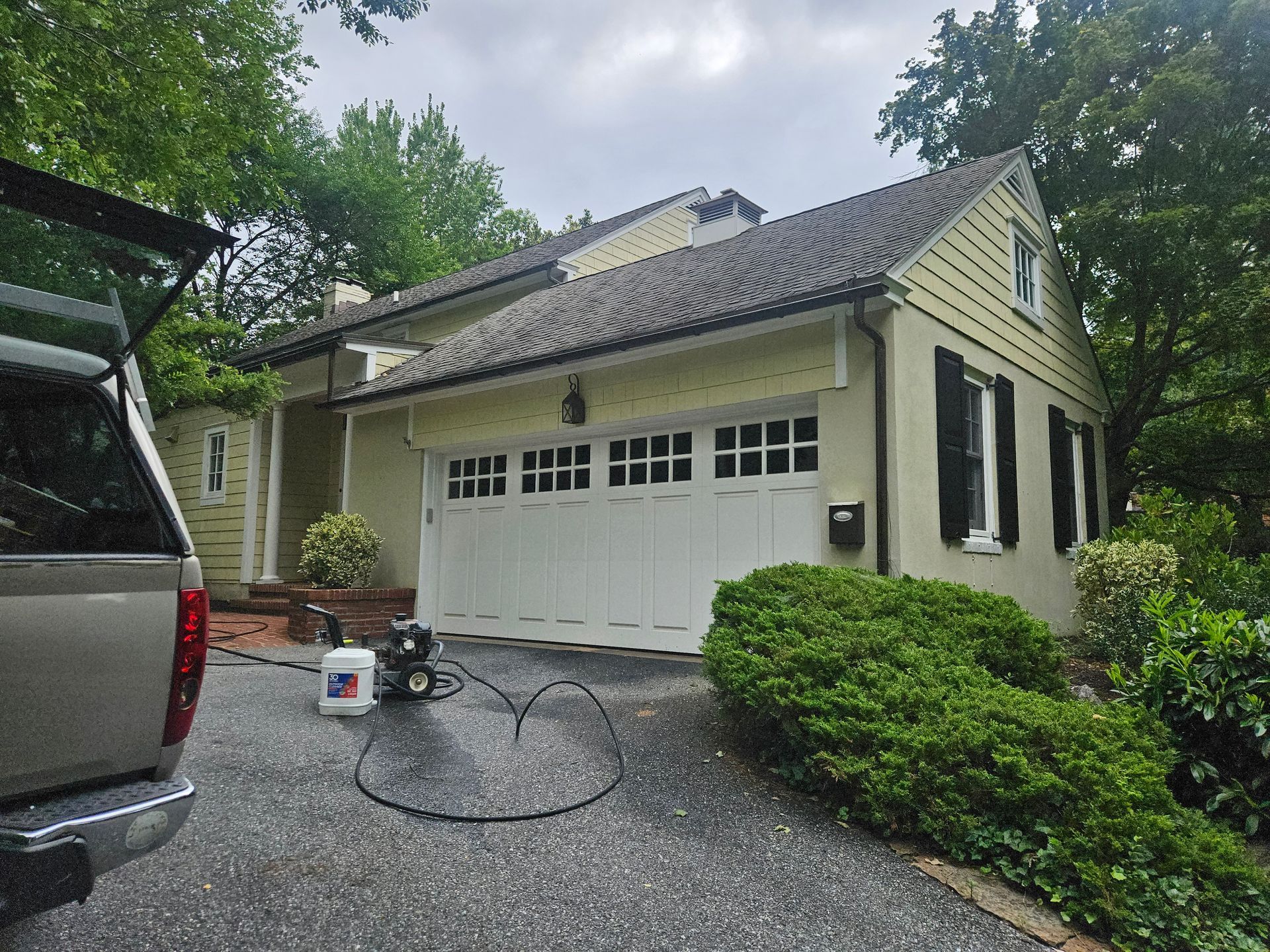 Gray concrete patio with hose on a sunny day.