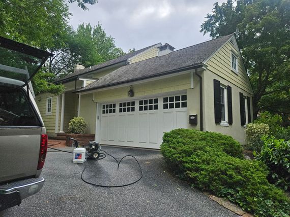 Gray concrete patio with hose on a sunny day.