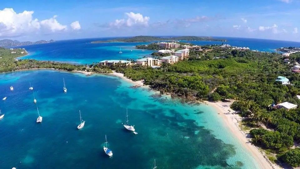 An aerial view of a tropical island with boats in the water.