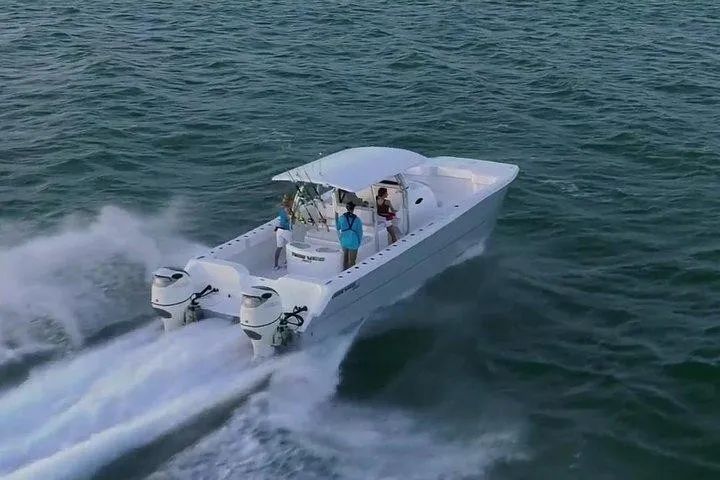 A white boat is floating on top of a body of water.