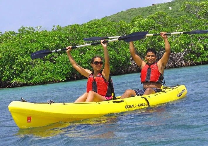 A man and a woman are in a yellow kayak