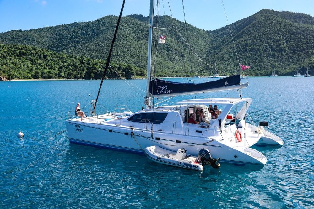 A sailboat is floating on top of a body of water with mountains in the background.