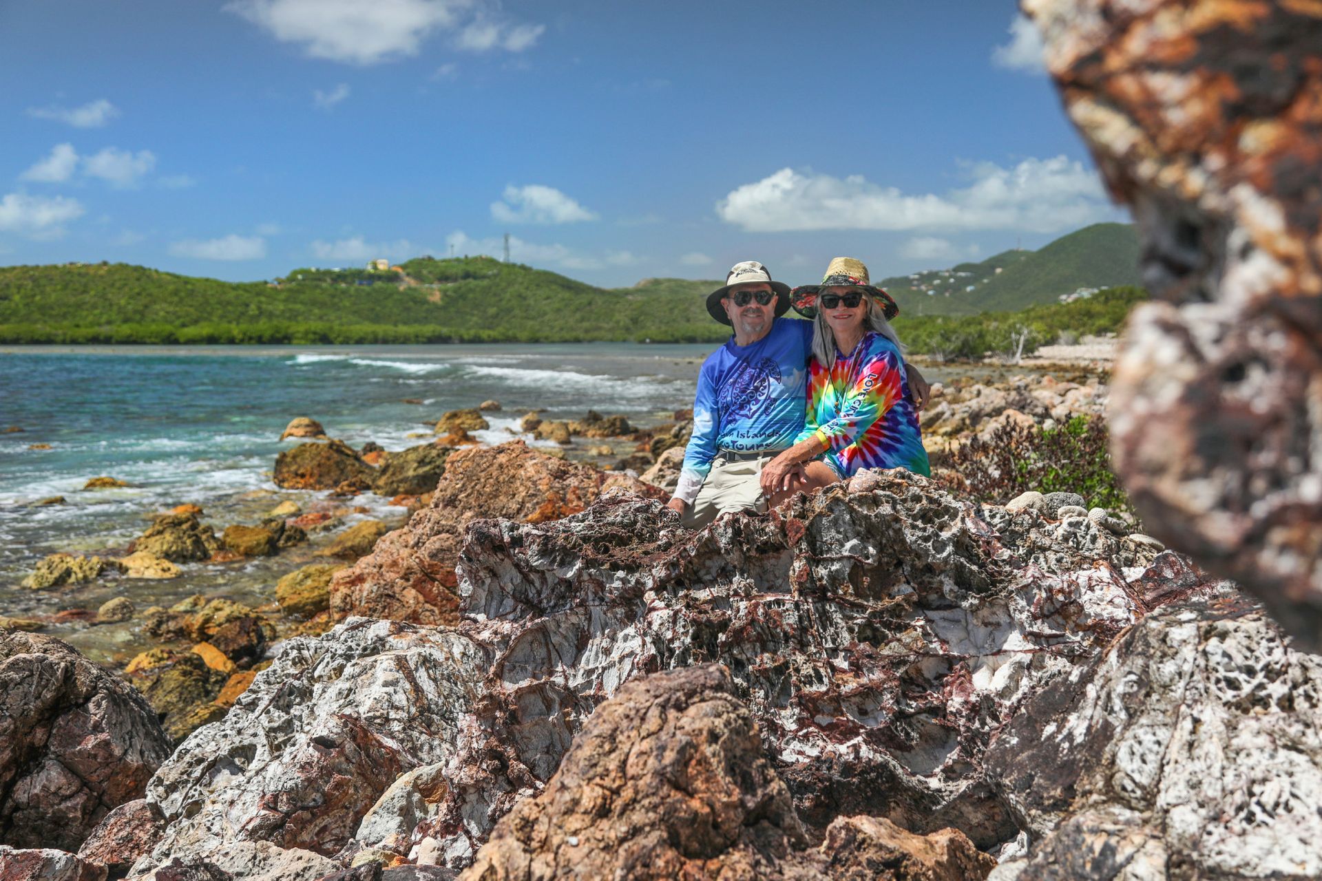 Couple sitting on rocks in the beach