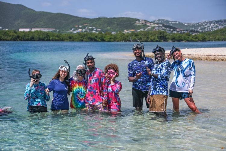 A group of people are posing for a picture in the water.