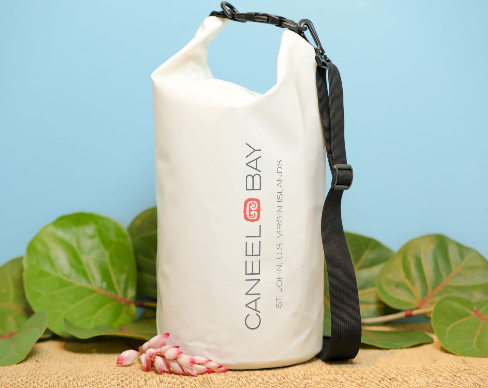 A white caneel bay dry bag with a black strap