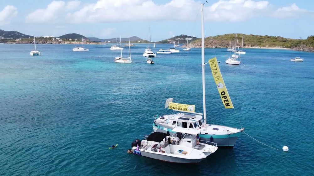 A group of sailboats are floating on top of a body of water.