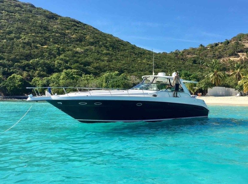 A boat is docked in the water near a beach.