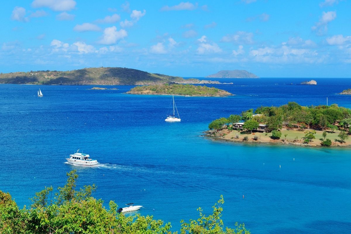 A boat is floating on top of a large body of water surrounded by small islands.