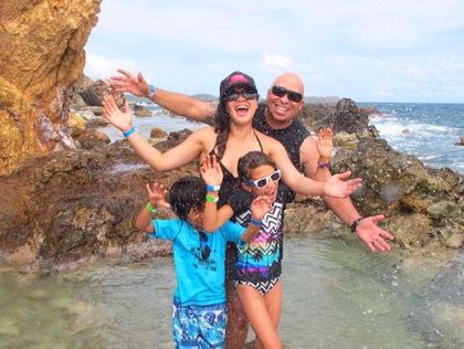 A family is posing for a picture on the beach.