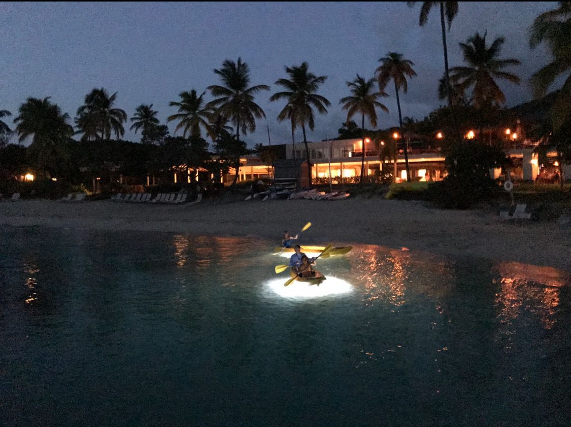 A person in a kayak on a beach at night