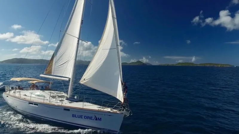 A sailboat is floating on top of a large body of water.