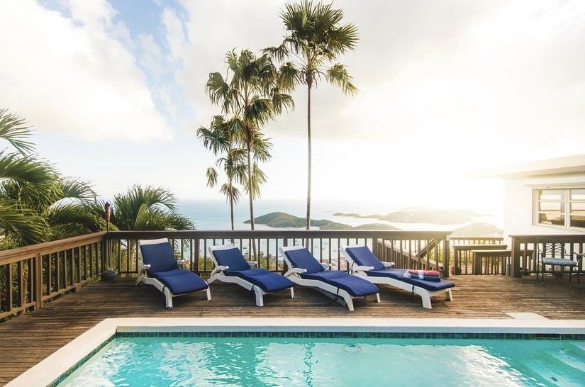 A swimming pool with a view of the ocean and palm trees