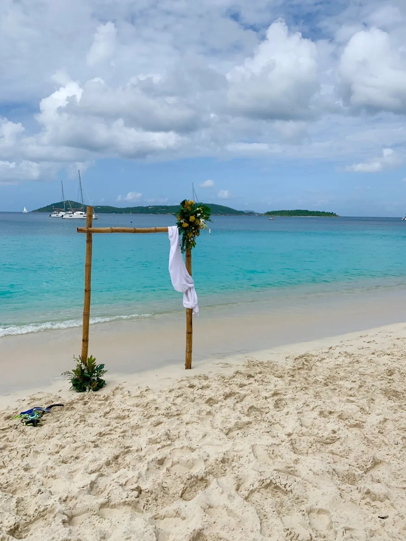A beach with a wooden arch and flowers on it