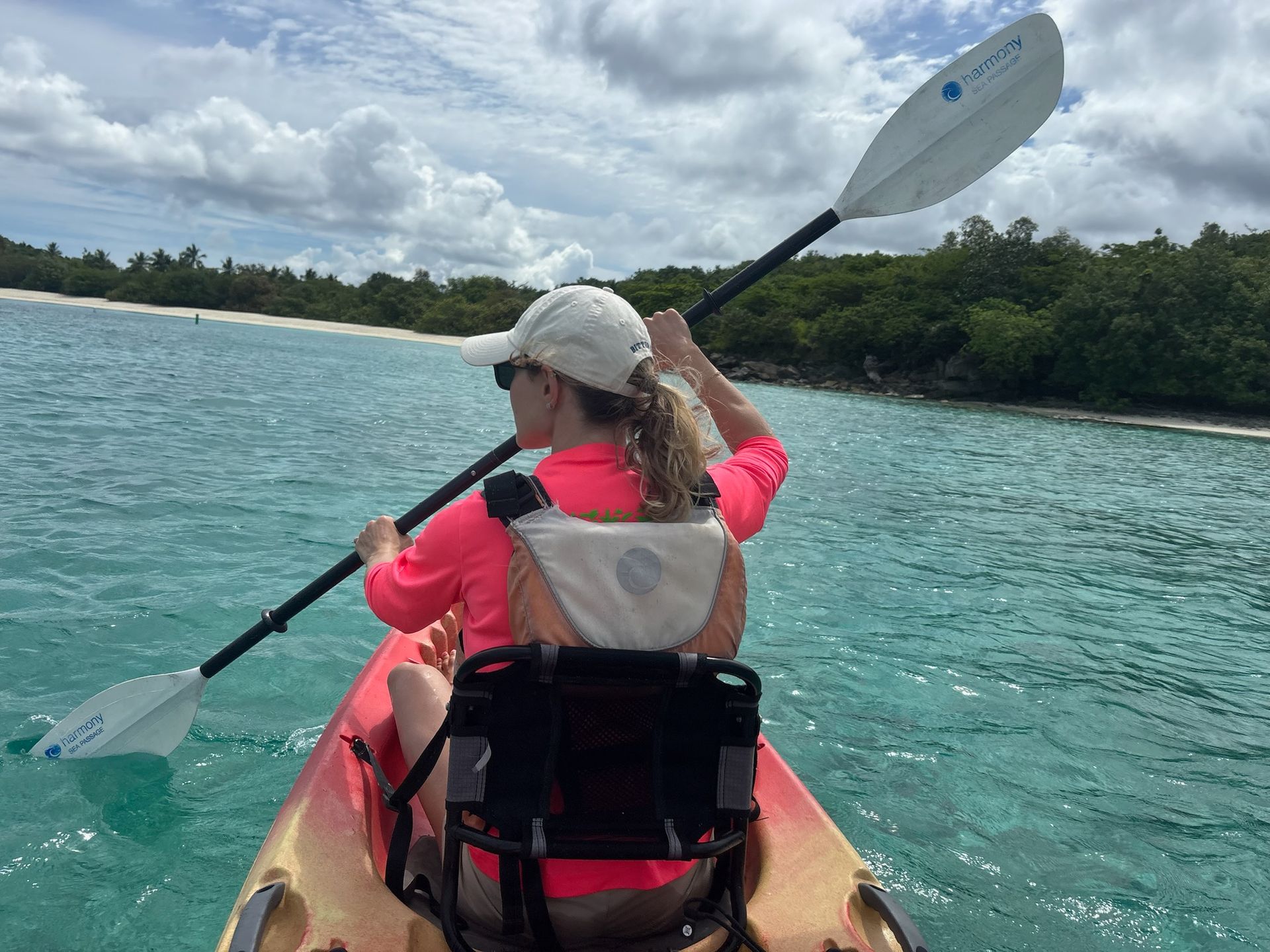 A person kayaks in the aqua colored water of St John