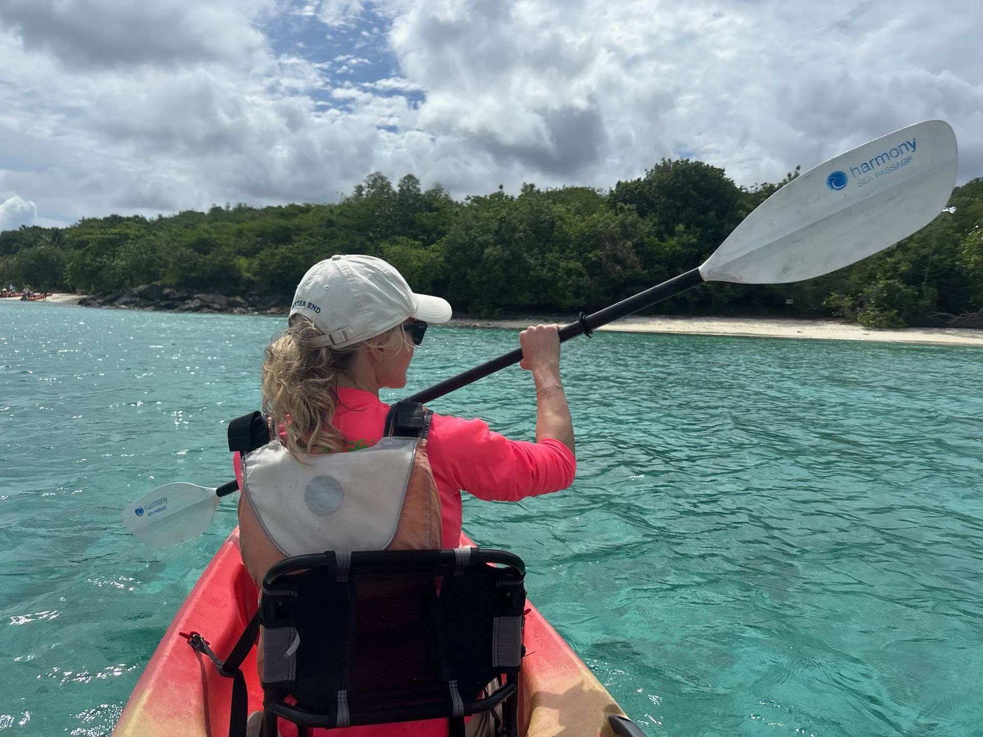 Two women are paddling yellow kayaks in the water.
