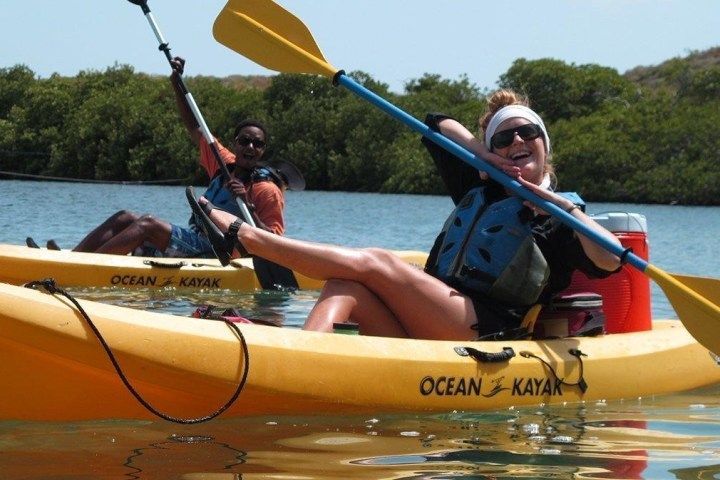 A woman sits in a yellow ocean kayak