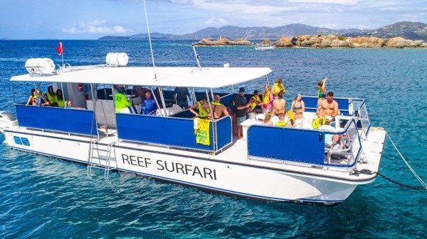 A boat filled with people is floating on top of a body of water.