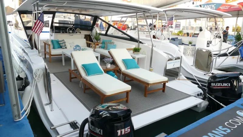 There are two lounge chairs on the deck of a boat.