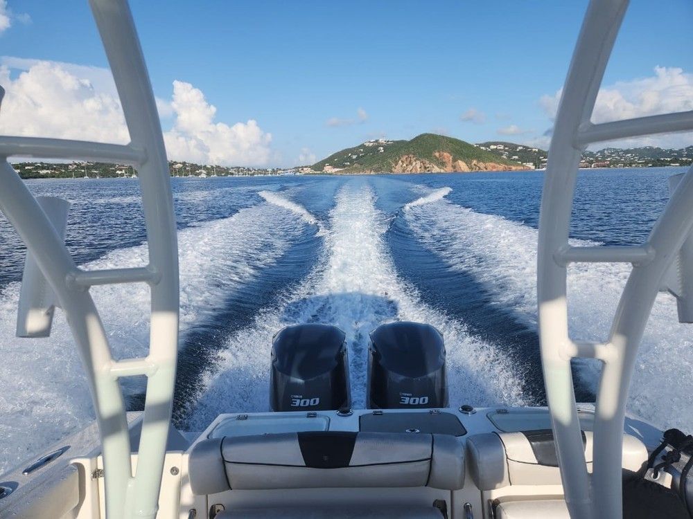 A boat is going through the water with a mountain in the background