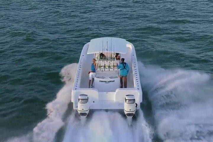 A white boat is floating on top of a body of water.