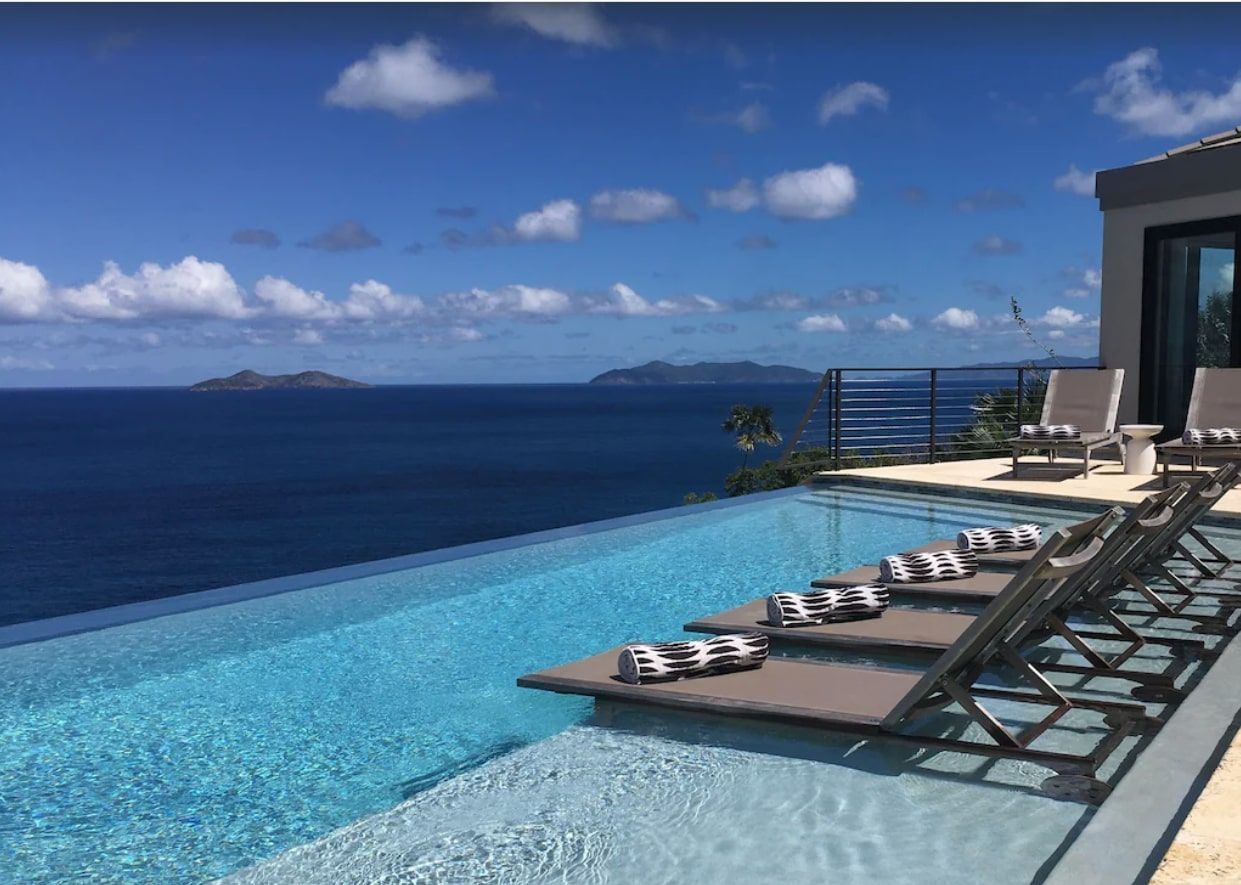 A large swimming pool with a view of the ocean.