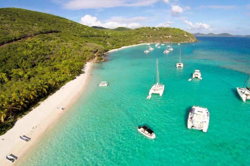 An aerial view of a tropical beach with boats in the water.