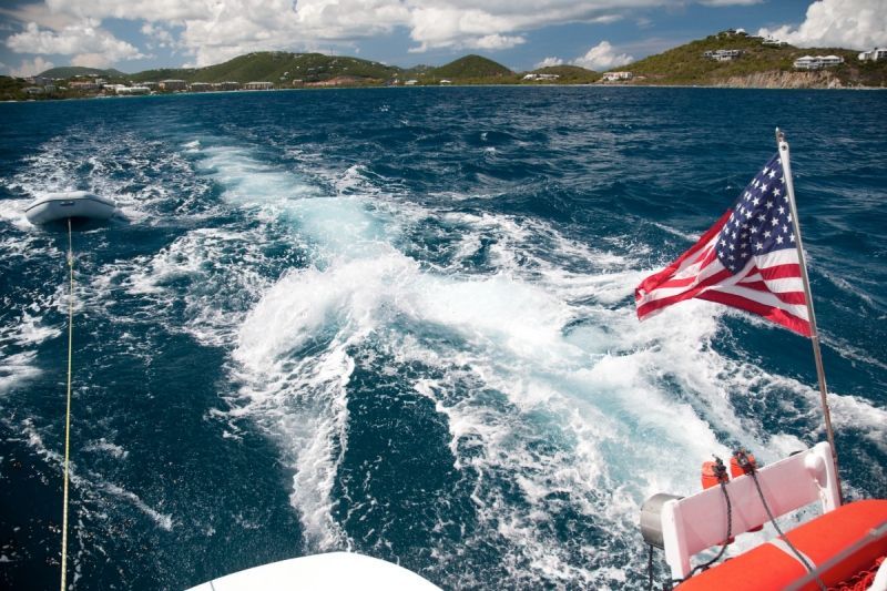 An american flag is flying from the back of a boat