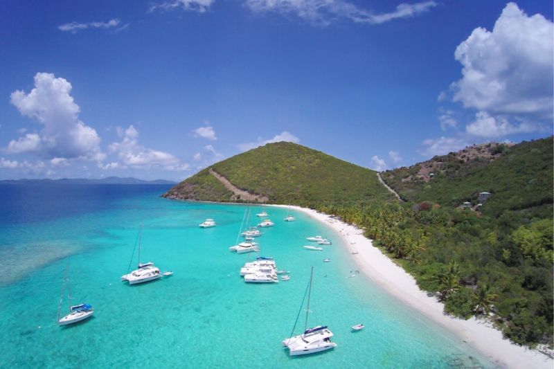 An aerial view of a beach with boats in the water