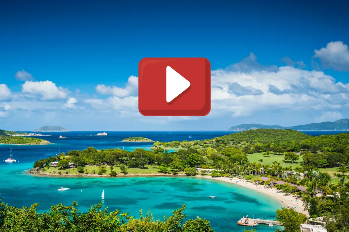 An aerial view of a tropical island with a play button in the foreground.