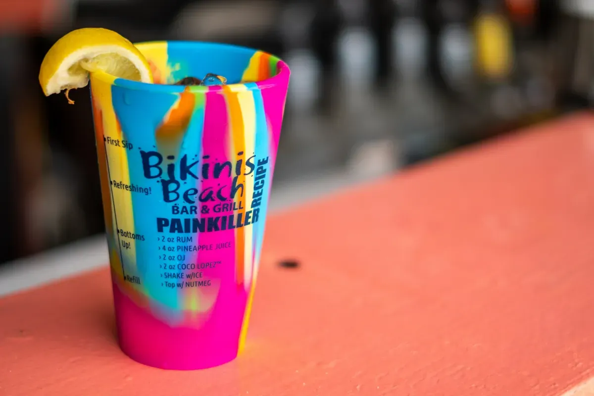 A bikini beach shot glass with a lemon slice in it