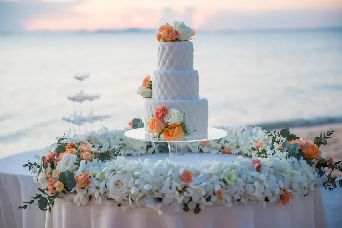 A wedding cake is sitting on top of a table decorated with flowers.