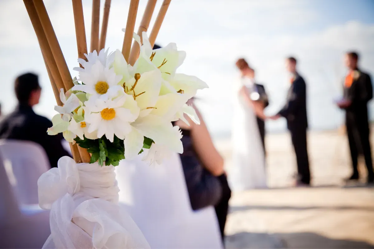 A bride and groom are getting married on the beach