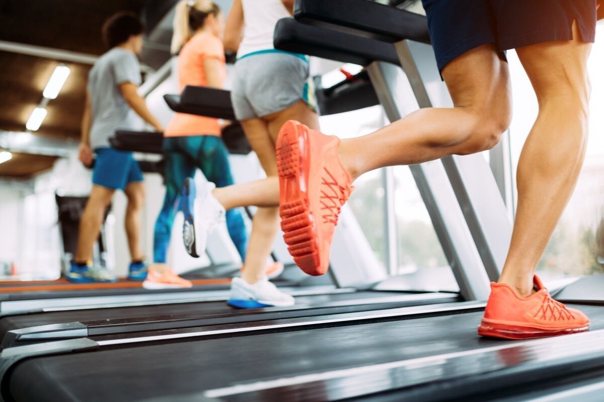 A group of people are running on treadmills in a gym.