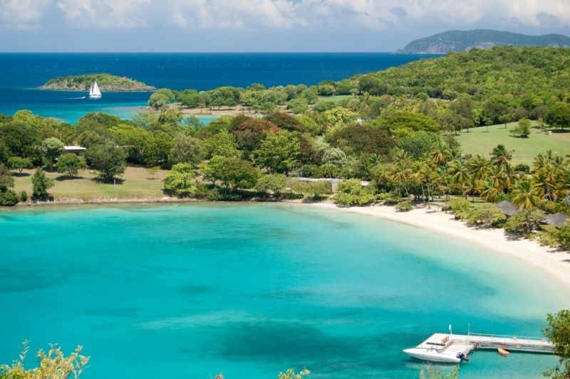 An aerial view of a tropical island with a dock and a boat in the water.