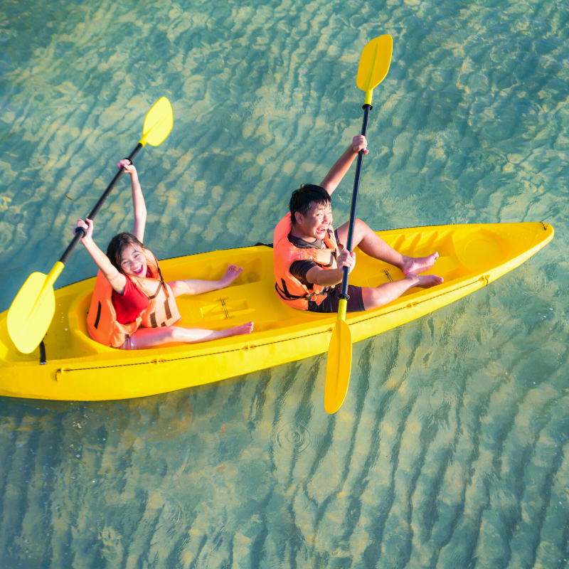 Two people in a yellow kayak with yellow paddles